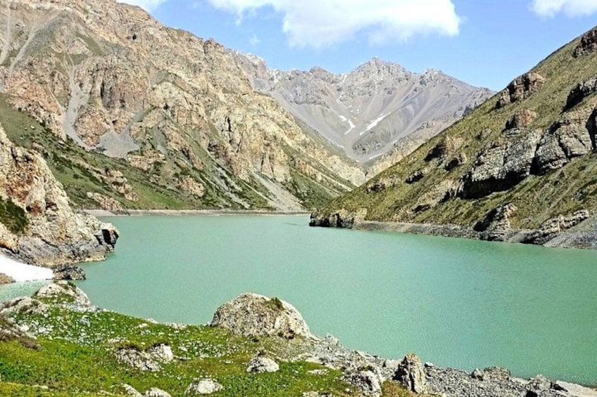 Un lago de montaña rodeado de terreno rocoso. 4