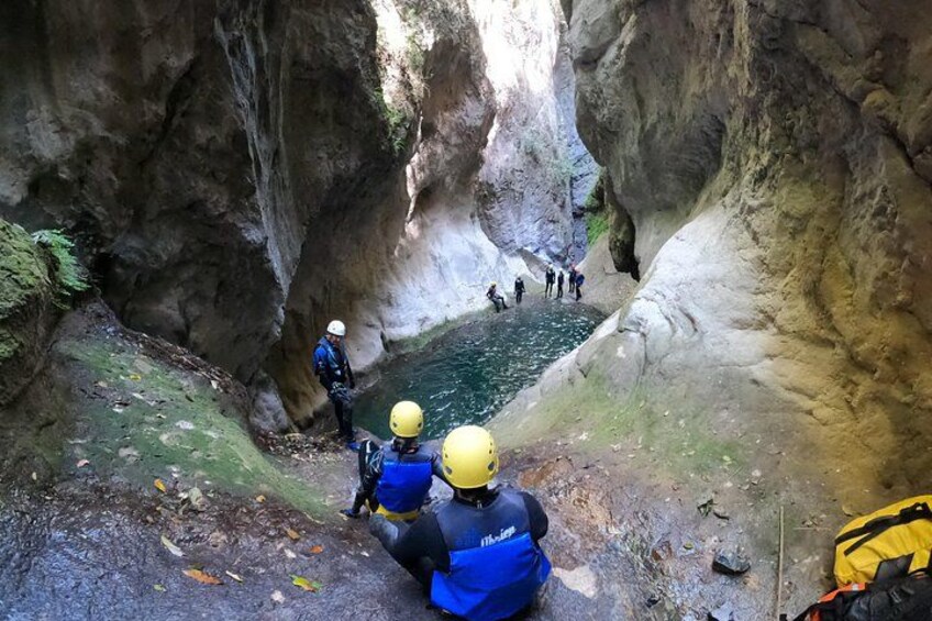 A group of people in a canyon with a water body. 4