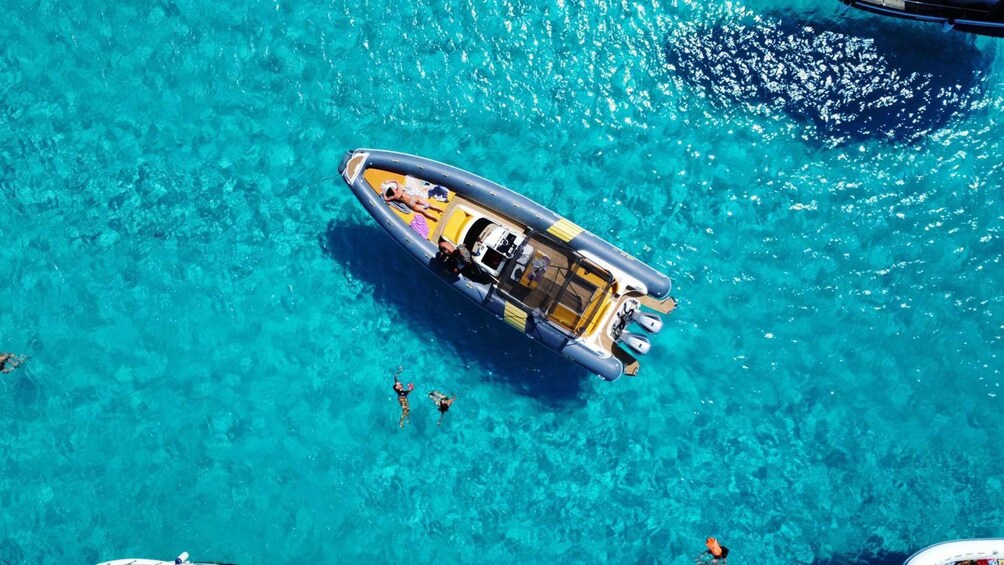 A small inflatable boat on clear turquoise water. 1