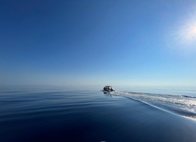 A boat moving across a calm sea under a clear sky. 2