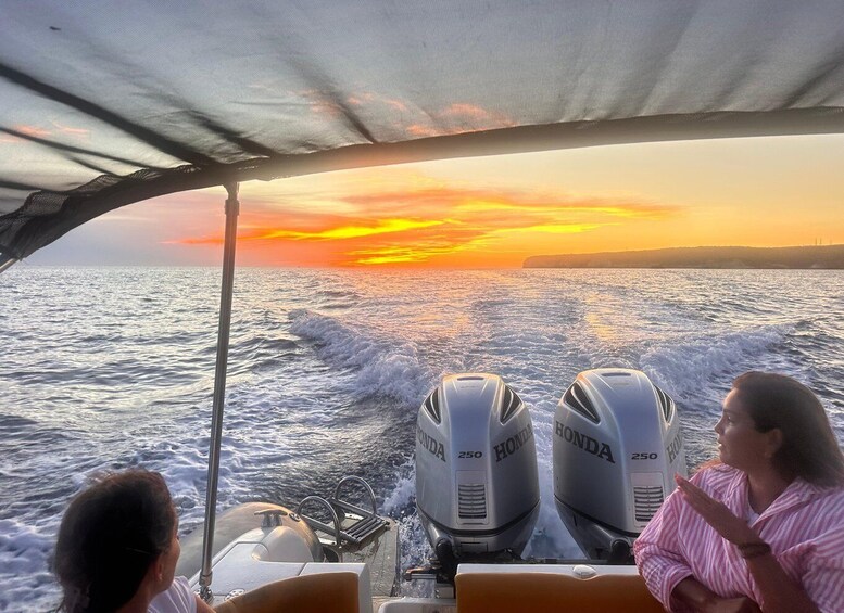 A boat with two Honda outboard motors, a person in a pink striped shirt, and a sunset over the ocean. 5