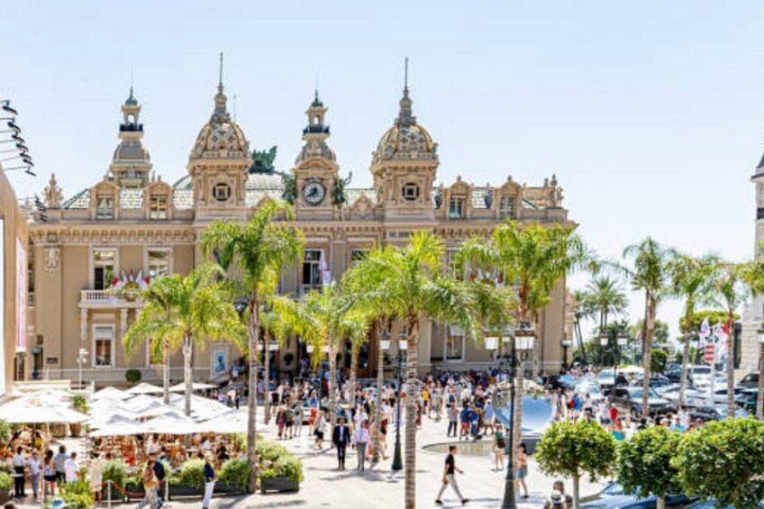 A historic building with ornate architecture, palm trees, and a bustling street scene. 2