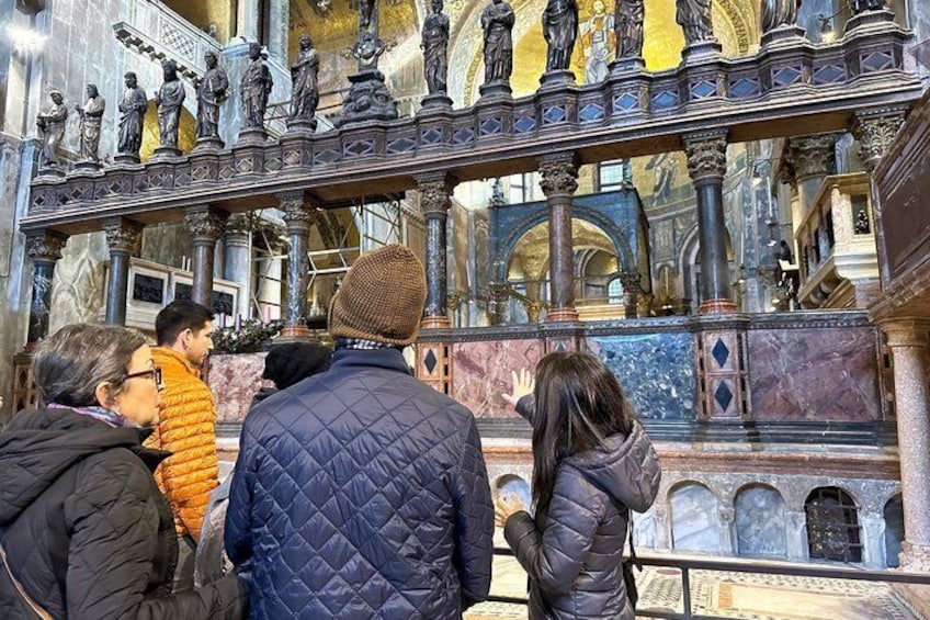 A group of people inside a church with ornate statues and marble floors. 4