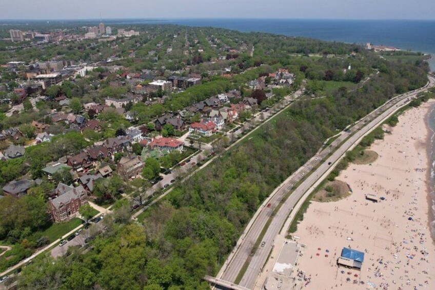 An aerial view of a coastal town with a beach, residential area, and a highway. 5