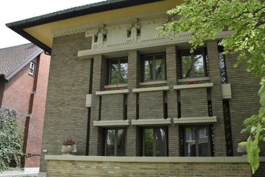 A multi-story building with a brick facade, large windows, and a small balcony area. 4
