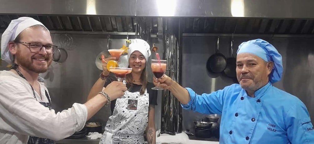 Chefs toasting with drinks in a kitchen. 5