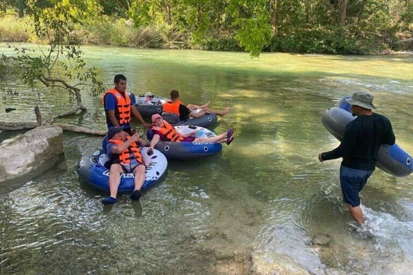 Personas en flotadores en un río rodeado de follaje. 1