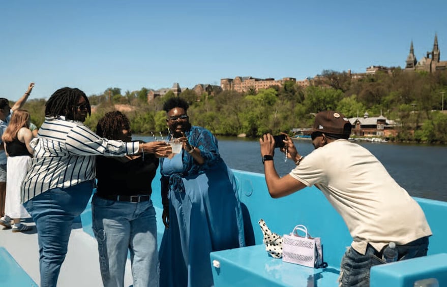 A group of people on a boat with a cityscape in the background. 1