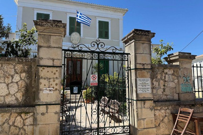 A building with a flag, a gate, and a sign. 2
