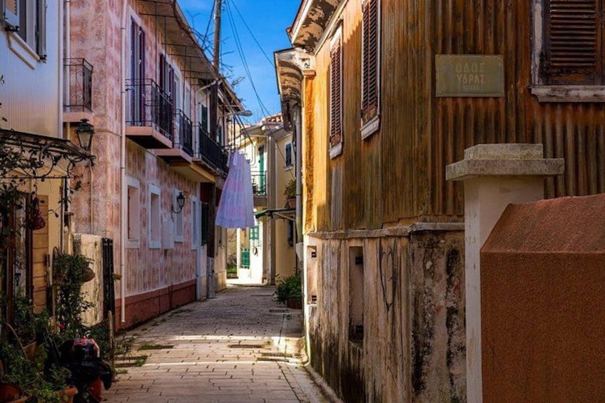 A narrow street flanked by old buildings with balconies and a sign reading 'Cade Yaryan.' 1