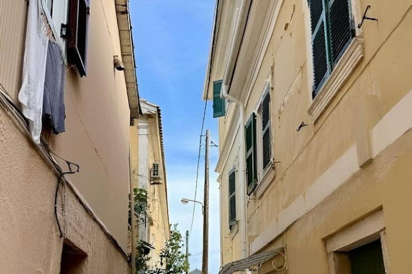A narrow street between buildings with laundry hanging on the walls. 4