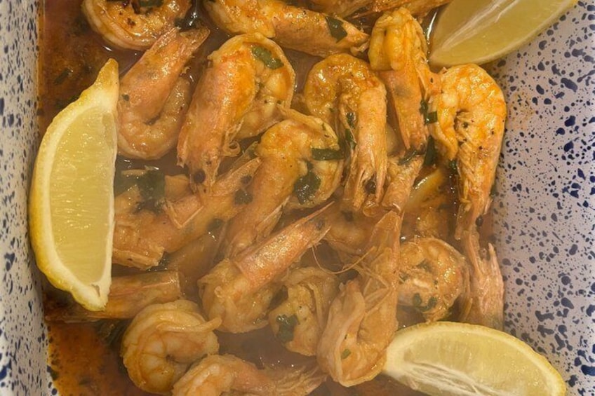 A box of cooked shrimp with lemon slices. 3