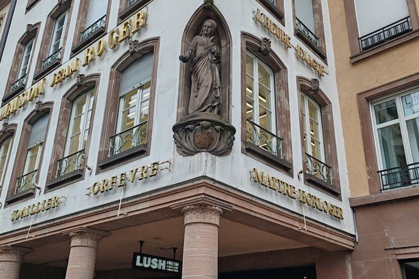Un edificio con detalles arquitectónicos ornamentados, incluyendo estatuas y molduras decorativas. 4