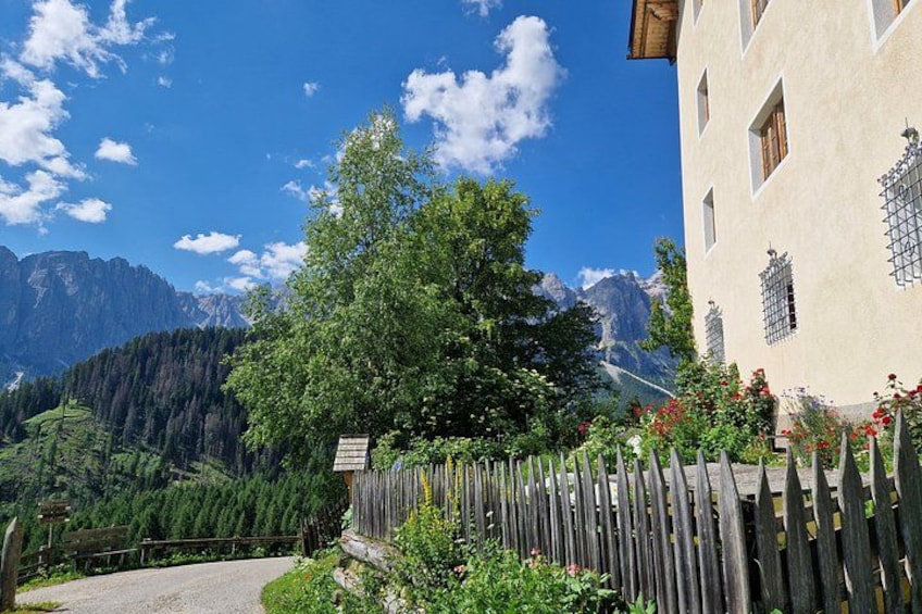 A mountain landscape with a wooden fence, a building with windows, and a clear blue sky. 5