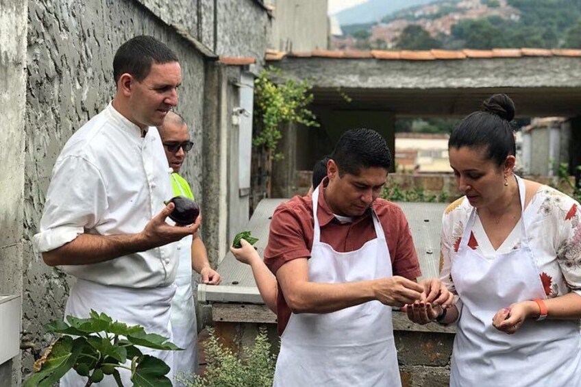 A group of people in aprons, possibly chefs, preparing food outdoors. 4