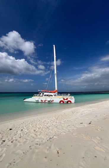 A sailboat named 'bebe' on a beach with clear turquoise water and a clear sky. 1