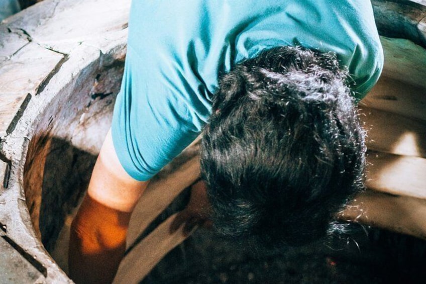 A person washing their hair in a wooden tub. 3