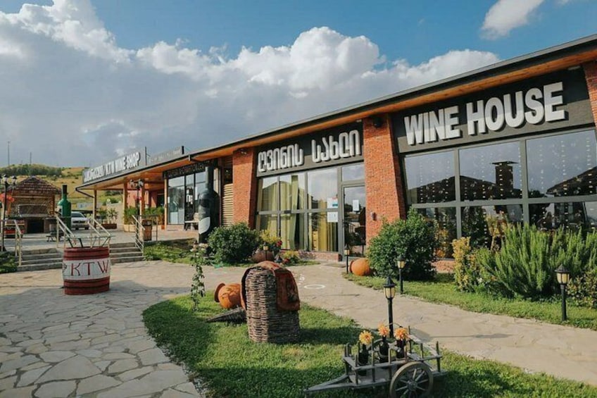 A wine house with a brick facade, large windows, and outdoor seating area. 4