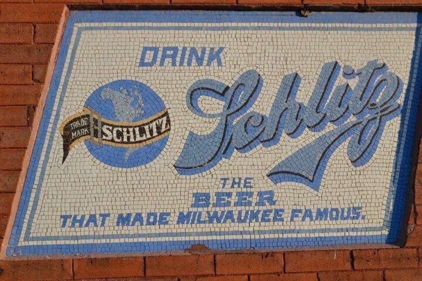 Ein Mosaikschild mit dem Text 'Drink Schlitz, The Beer That Made Milwaukee Famous'. 2