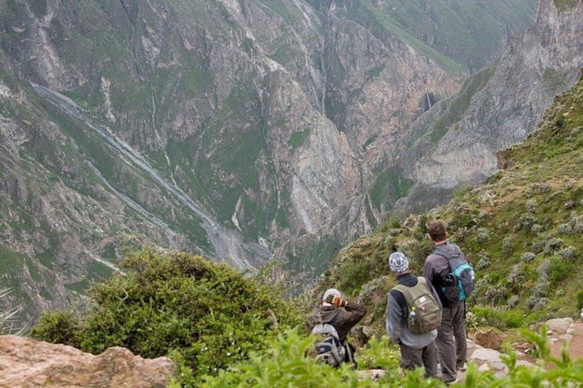 Due escursionisti su un sentiero montano con terreno roccioso e scarsa vegetazione. 2