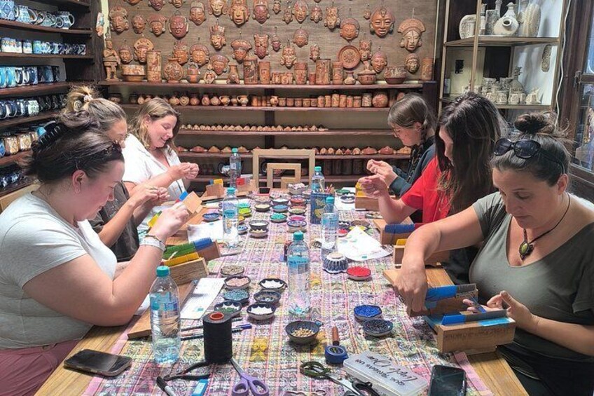 Un grupo de personas realizando una actividad artesanal en una mesa con diversas herramientas y materiales. 2