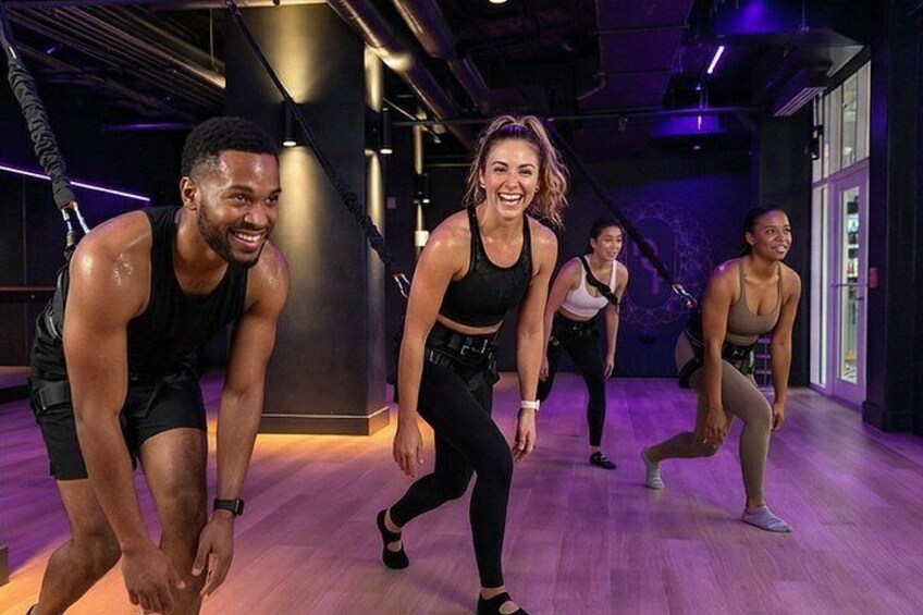 Een groep mensen in een dansstudio met houten vloeren en spiegels. 3