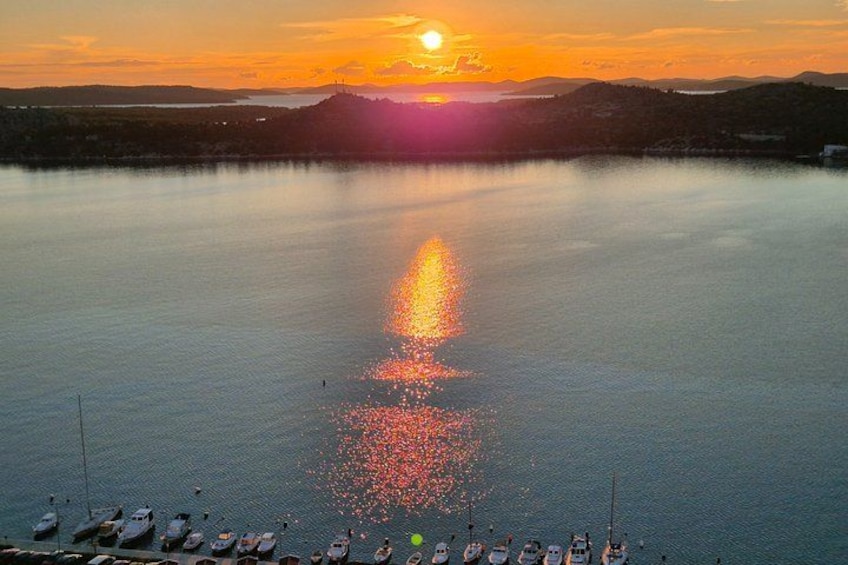 Solnedgang over en rolig sø med både ved bredden. 4