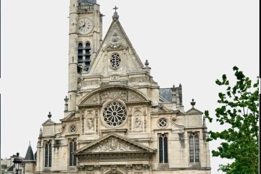 En historisk kirke med et markant klokketårn og detaljeret facade. 1