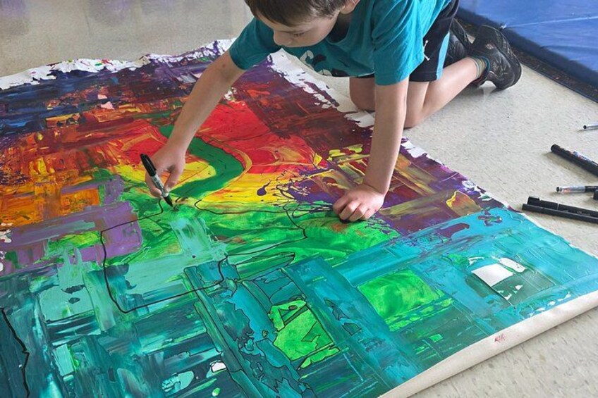 A person painting a large, colorful abstract mural on a floor. 3