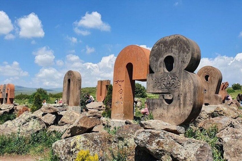 Ancient stone structures with inscriptions, set against a clear sky. 1