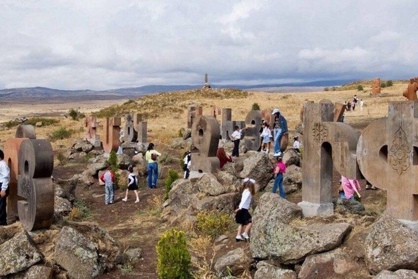 A historical site with large stone structures and visitors exploring the area. 4