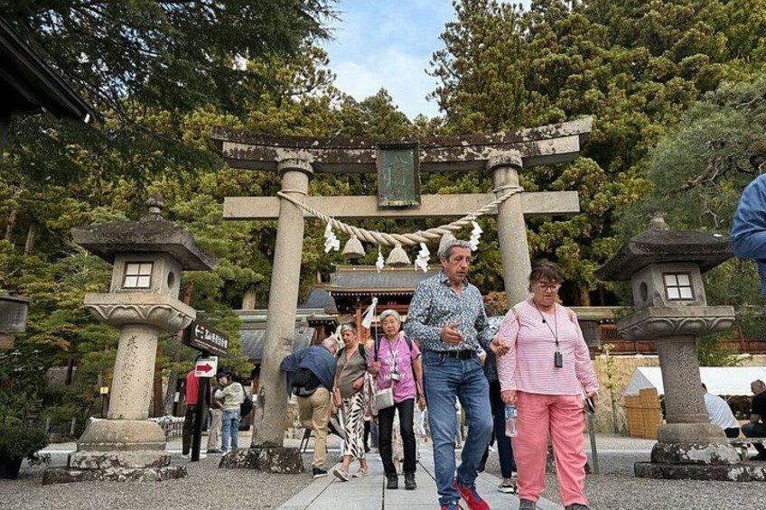 A traditional Japanese torii gate with visitors walking through. 3