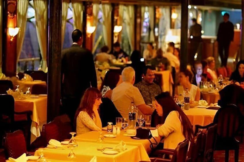 A busy restaurant with diners seated at tables, some with drinks and menus. 5