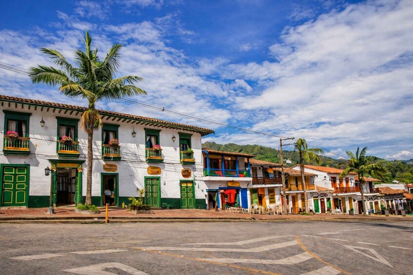 A street with colorful buildings, palm trees, and a clear blue sky. 4
