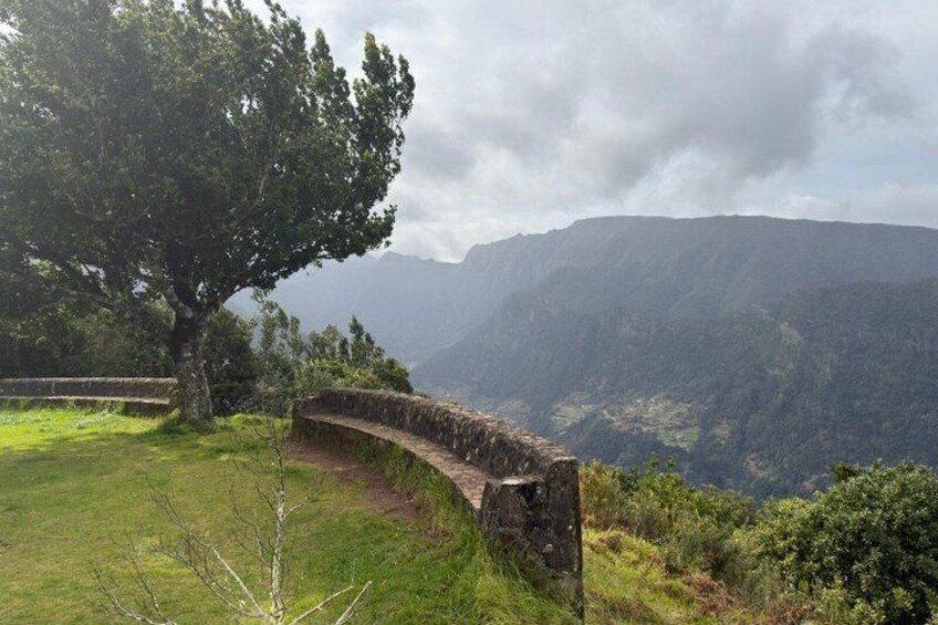 A stone bridge, a large tree, and a mountainous landscape. 3