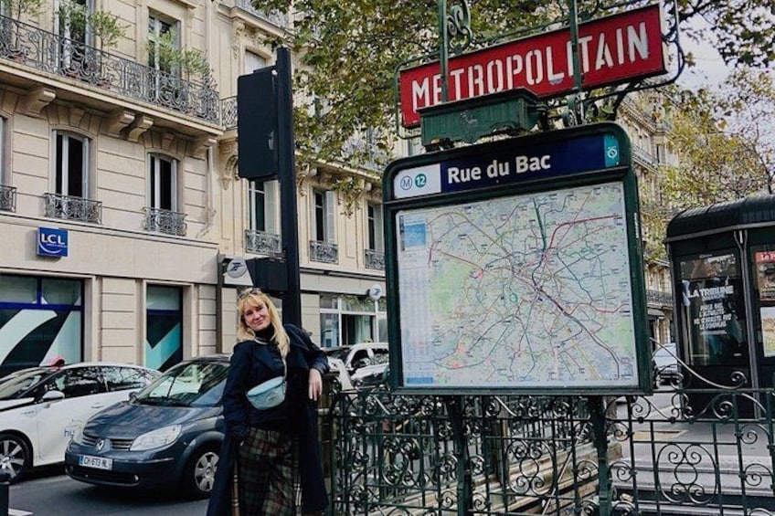 Una señal de calle con el texto 'METROPOLITAIN' y 'Rue du Bac', un mapa y un autobús. 4