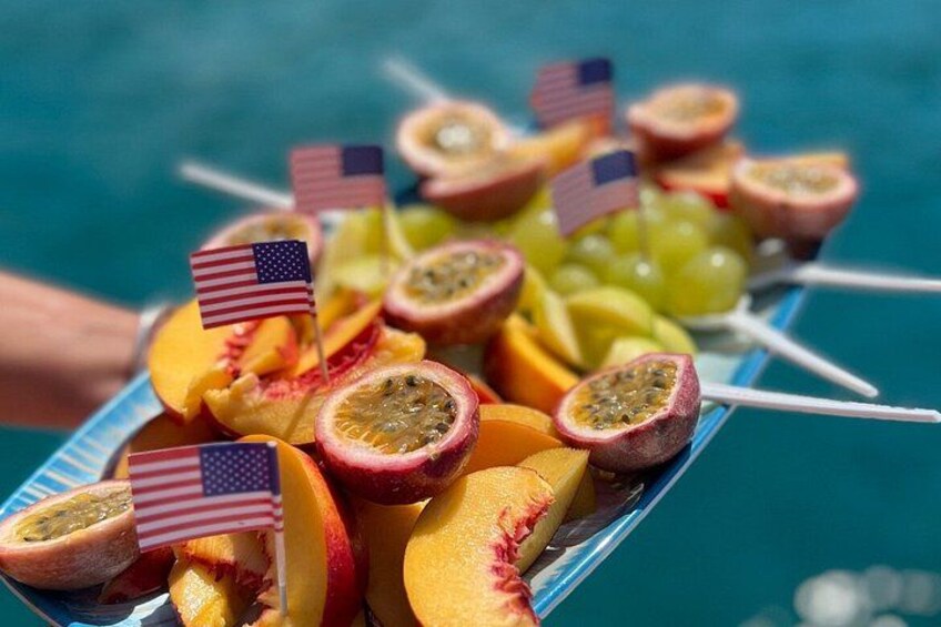 A tray of sliced fruits with American flags. 2