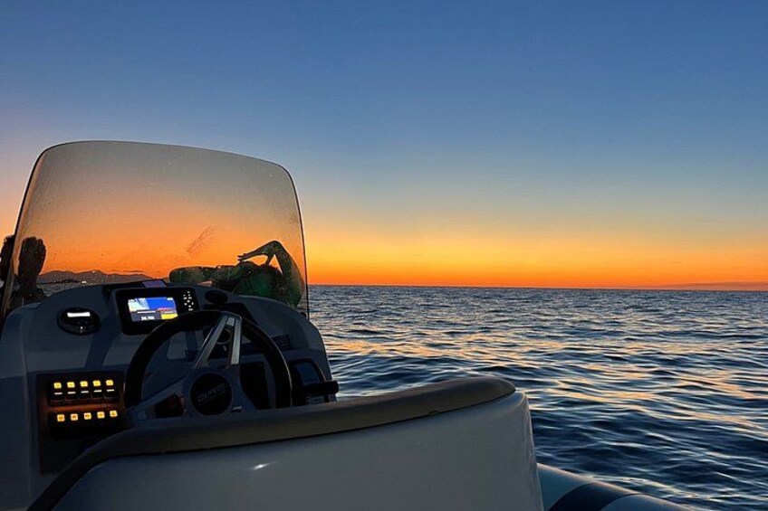 A boat's dashboard with a digital display, steering wheel, and control panel. 4