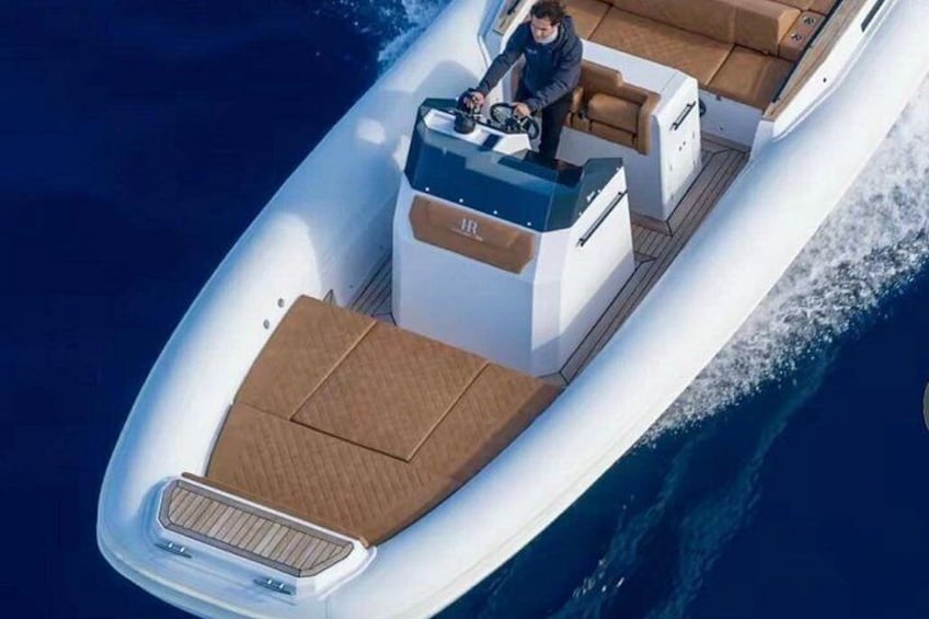 Ein elegantes, modernes Boot mit geräumiger Deckfläche und einer steuernden Person. 3