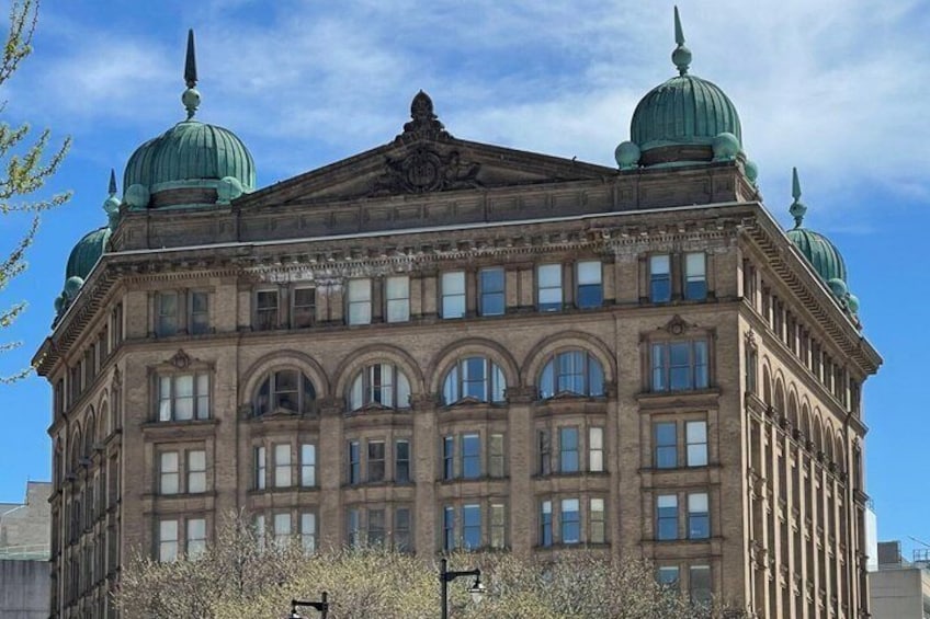 A historic building with a central dome and two smaller domes on either side, surrounded by a clear blue sky. 2