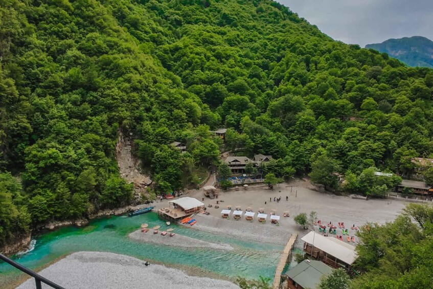 A coastal area with a beach, boats, and a forested hillside. 4