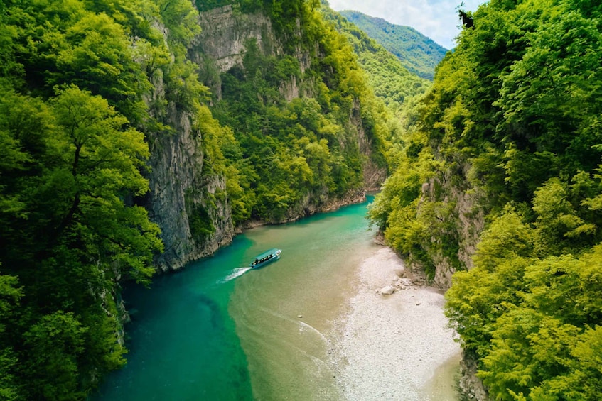 A river winding through a canyon with dense green foliage on both sides. 3