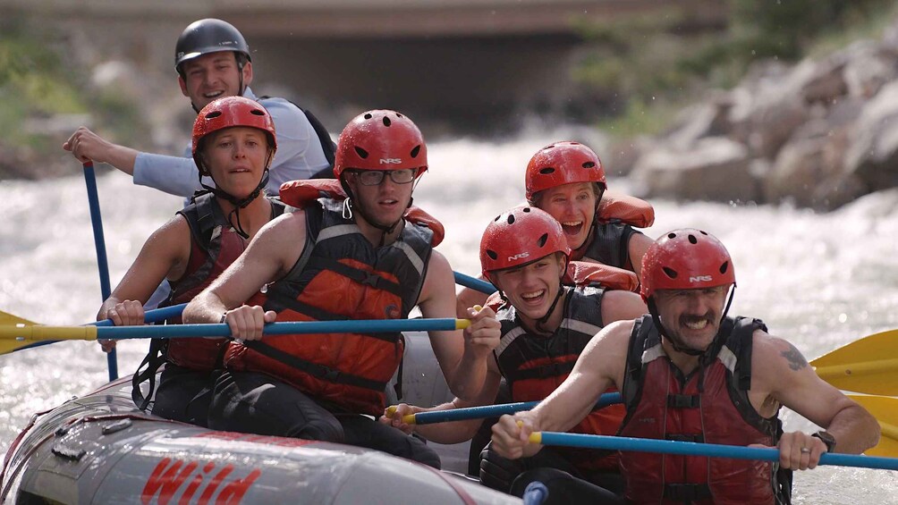 A group of people in a raft navigating a river. 1