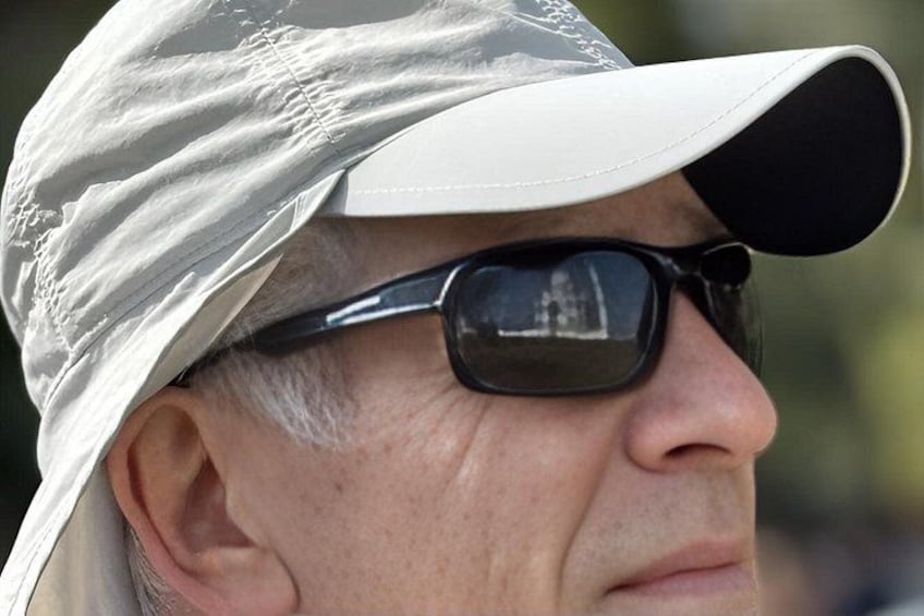 A person wearing a white cap and sunglasses. 5