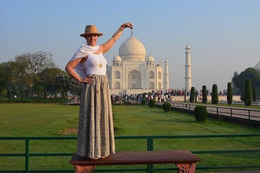 Una persona in piedi su una piattaforma di fronte al Taj Mahal, con il monumento sullo sfondo. 2