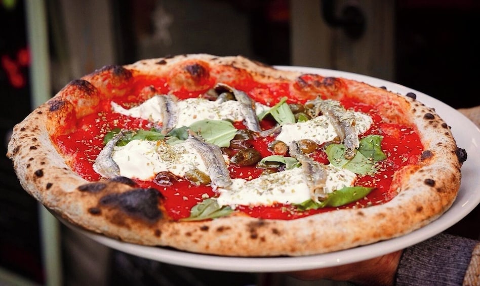 A pizza with toppings on a white plate. 1