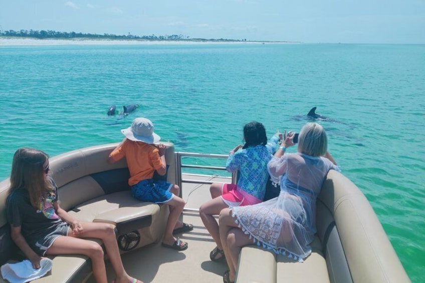 Un grupo de personas en un barco con vista despejada al océano y a la costa distante. 1