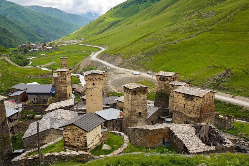 A historic village with stone buildings and a winding road. 3