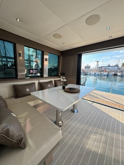 A modern yacht interior with a sofa, table, and a view of a marina. 1