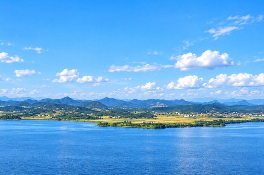 A lake surrounded by mountains and a small island with buildings. 4